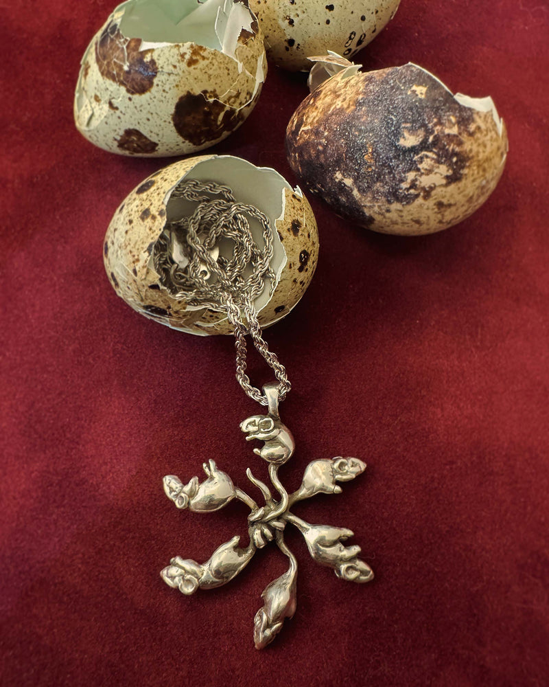 rat king necklace coming out of a cracked eggshell