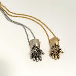 silver and gold fly in hand insect baby doll hand charm necklace
