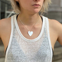 model wearing mother of pearl dainty layer heart charm necklace